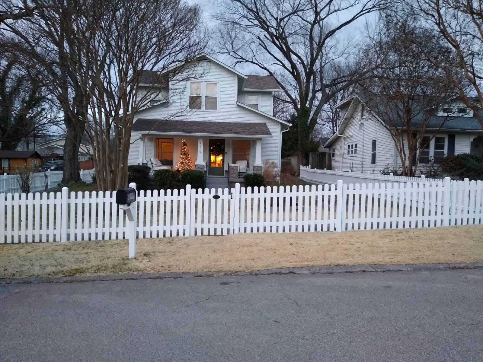 After — beautiful Nashville home with freshly painted white picket fence, warm lighting