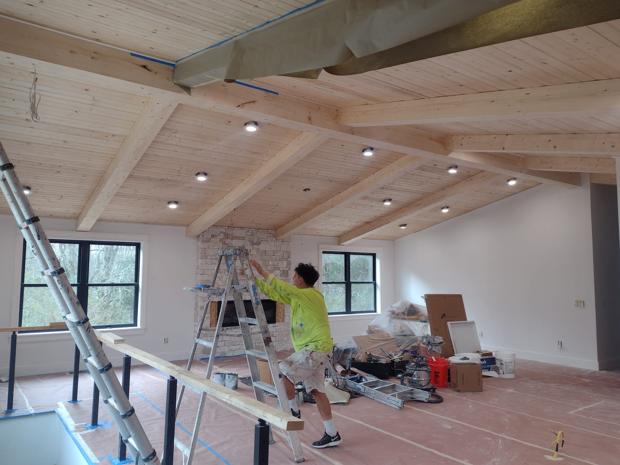 Lopez Painting crew member painting interior of Nashville home with exposed beam ceiling